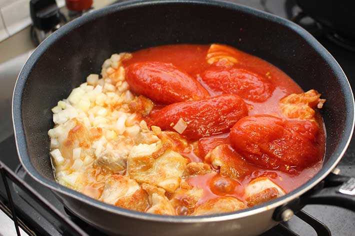 鶏肉とタマネギを焼き、トマトを入れる